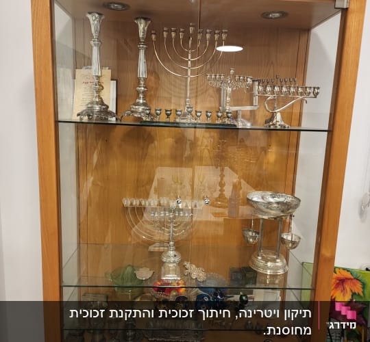 ויטרינה מזכוכית עם חנוכיות וכלי כסף